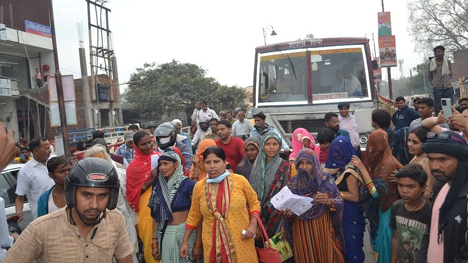 जाम के दौरान अलीगढ रोड पर कार को रोकती महिलाएं
