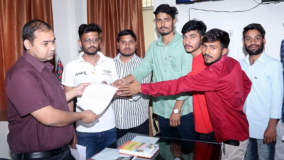 एडीएम सिटी अमित कुमार भट्ट को शिकायत पत्र देते एएमयू छात्र।