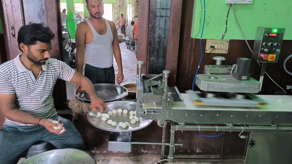 चमचम के गोले बनाते हुए कारीगर