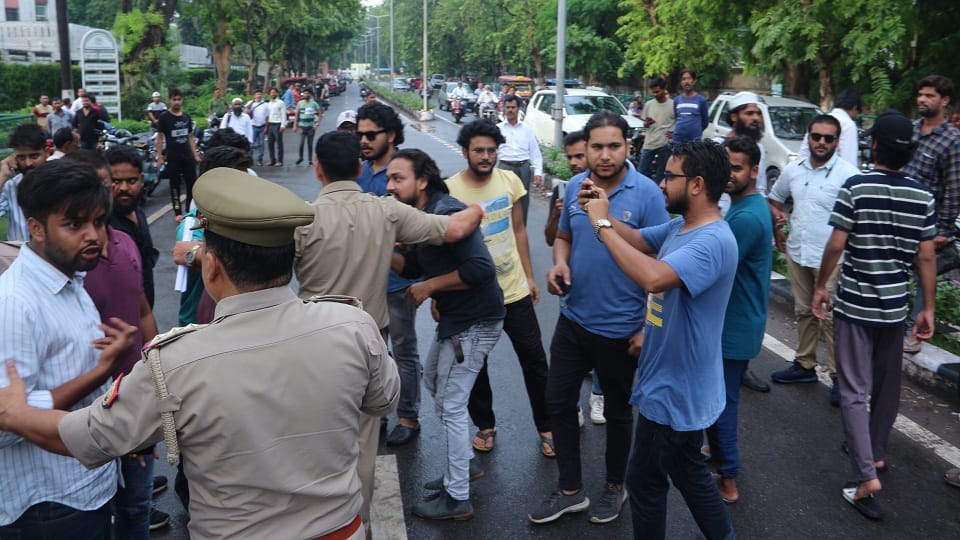 एएमयू रजिस्ट्रार दफ्तर के बाहर नारेबाजी कर रहे छात्रों को हटाते पुलिस अधिकारी