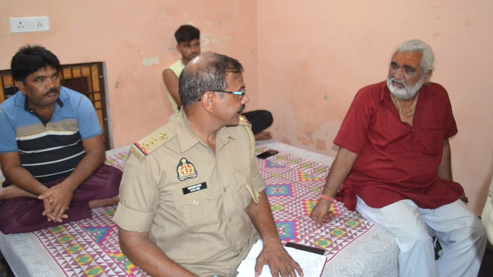 ट्रेन में गोलीबारी के आरोपी चेतन के पैतृक गांव मीतई में उसके ताऊ भगवान सिंह से जानकारी करते चंदपा कोतवाल संजय सिंह।
