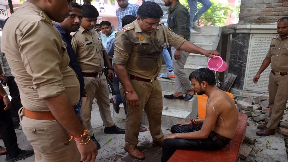 छात्र पर पानी डालती पुलिस