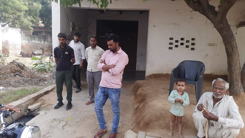 बच्ची की मौत के बाद घर पर उसके पिता रिंकू से बातचीत करते आसपास के लोग