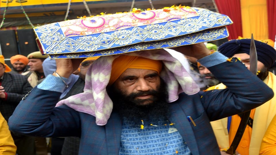 गरूगोविन्द सिंह प्राकाशोत्सव पर निकाते गए नगर कीर्तन के दौरान   ग्रन्थ साहेब को सरपर रखकर रथ में लेत जाते सीएमओ मंजीत सिंह