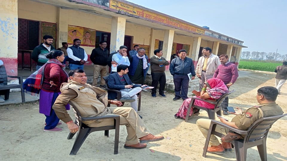 पूर्व माध्यमिक विद्यालय के गेट पर बैठे बीएसए एवं अन्य अधिकारी