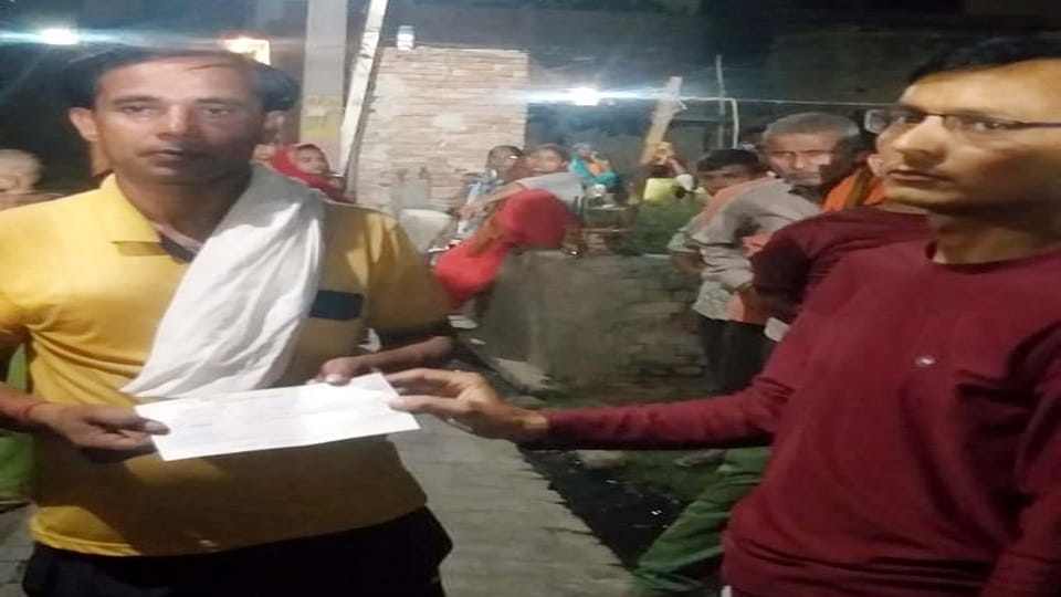मृतक के चचेरे भाई किशन और किशनू को चेक देते फैक्टरी के अकाउंटेंटेंट गैरव शर्मा