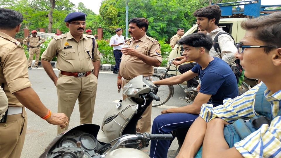 सिविल लाइन्स रोड पर स्कूटी चला रहे नाबालिकों को समझाते एसपी ट्रैफिक मुकेश चंद उत्तम व पुलिस कर्मी