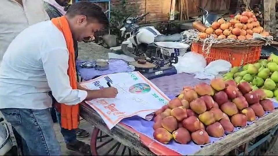 रामघाट रोड कावड़ मार्ग पर हिंदूवादी संगठन द्वारा फल की दुकान पर नाम लिखते दीपक आजाद