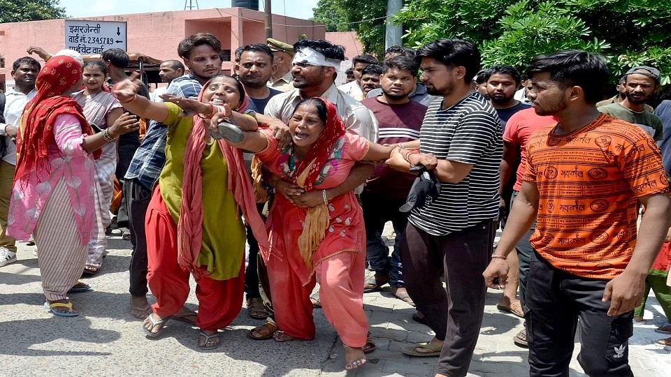 थाना सासनी गेट के पीछे अनुज की चाकुओं की हत्या के बाद मलखान सिंह जिला अस्पताल में हंगामें के दौरान दरोगा पर चप्पल मारने के लिए दौड़ती बहन ममता को पकड़ता अमित