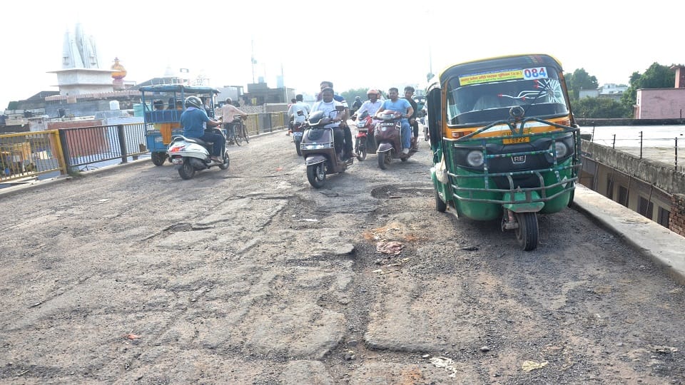 छर्रा अड्डा पुल पर हो रहे गड्ढों से बचकर निकलते वाहन सवार