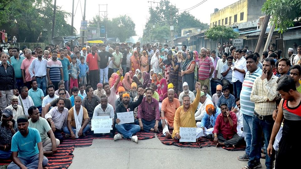 मौत के बाद खैर रोड पर शव रखकर धरने पर बैठे परिवार के लोग