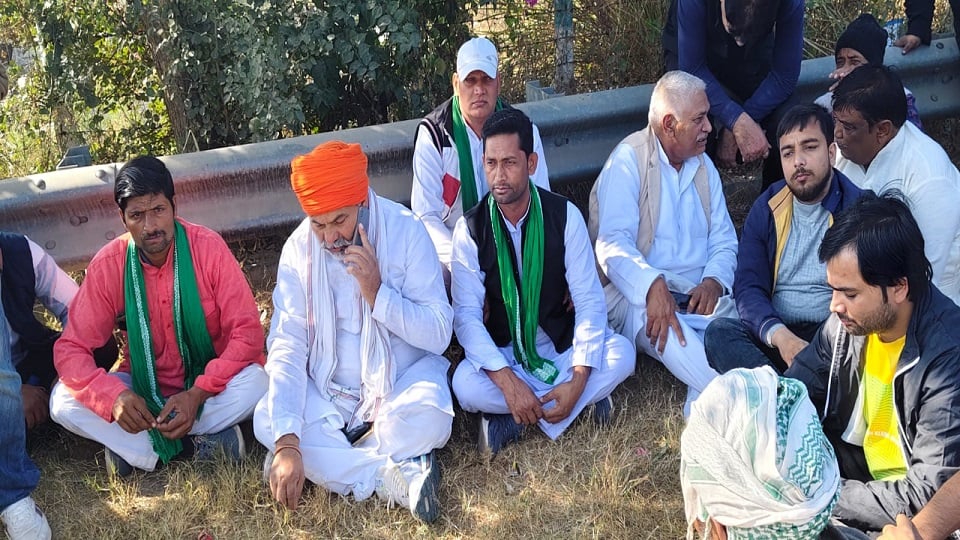 नोएडा की महापंचायत में जाने से रोके जाने पर टप्पल में यमुना एक्सप्रेस वे के किनारे ही धरने पर बैठे भाकियू नेता राकेश टिकैत