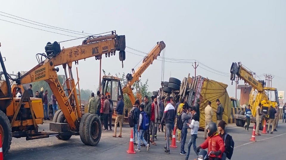 पलटे ट्रक को सही करतीं क्रेन