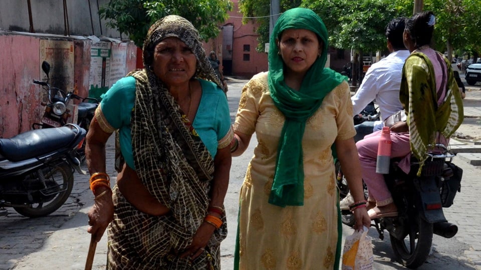 मलखान सिंह जिला अस्पताल में दिखाने के बाद व्हील चेयर न मिलने पर वृद्धा रानी देवी को ले जाती बहू