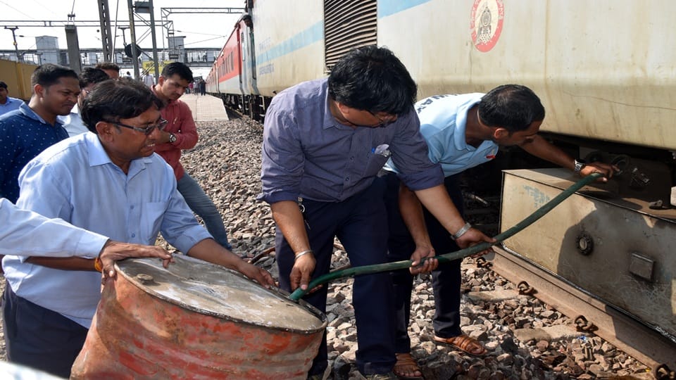 टैंक को खाली करते कर्मचारी