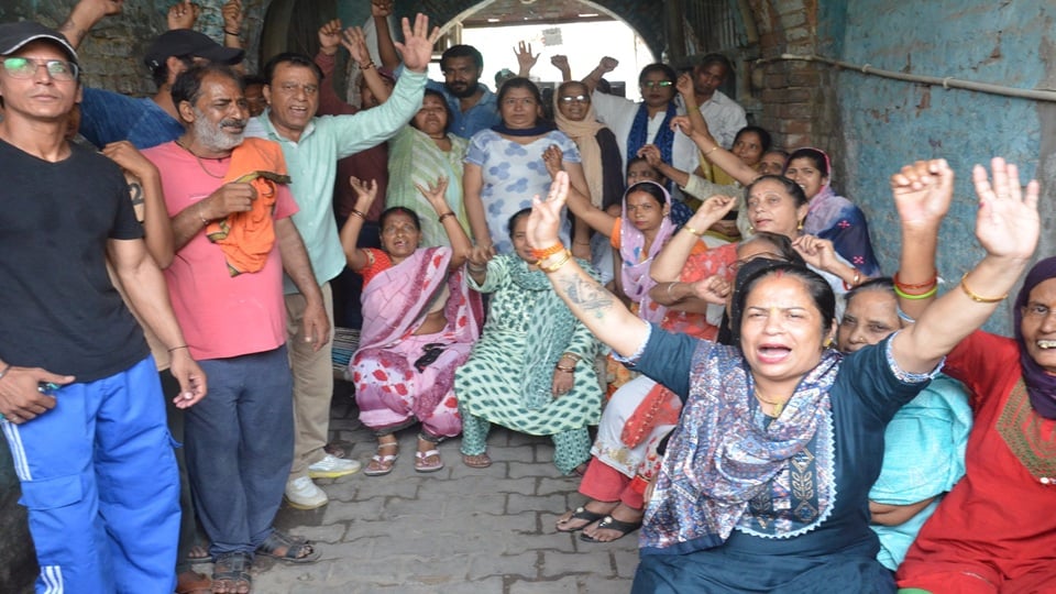 मीनाक्षी पुल के नीचे रामदेवी धर्मशाला  को खाली कराने को लेकर विरोध प्रदर्शन करती महिलाएं व लोग