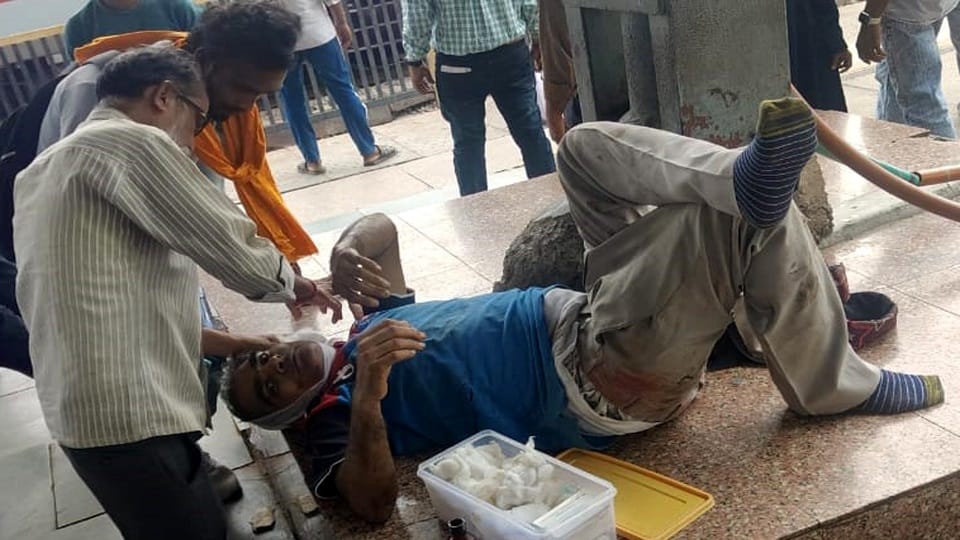 रेलवे स्टेशन के प्लेटफार्म नम्बर दो पर ट्रेन से उतरने के दौरान घायल हुए वितेंदर कुमार का उपचार करते रेलवे के डॉक्टर