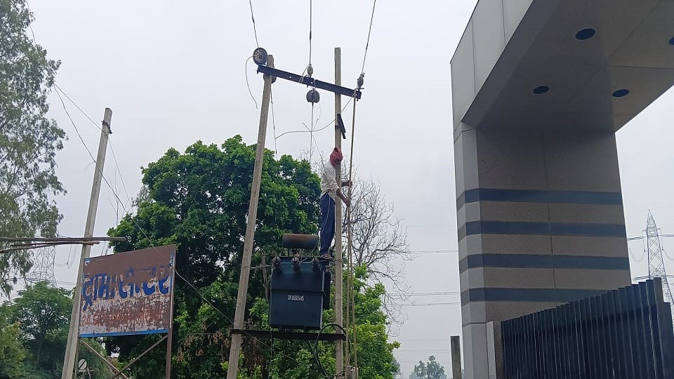 बिजली लाइन सही करता कर्मचारी