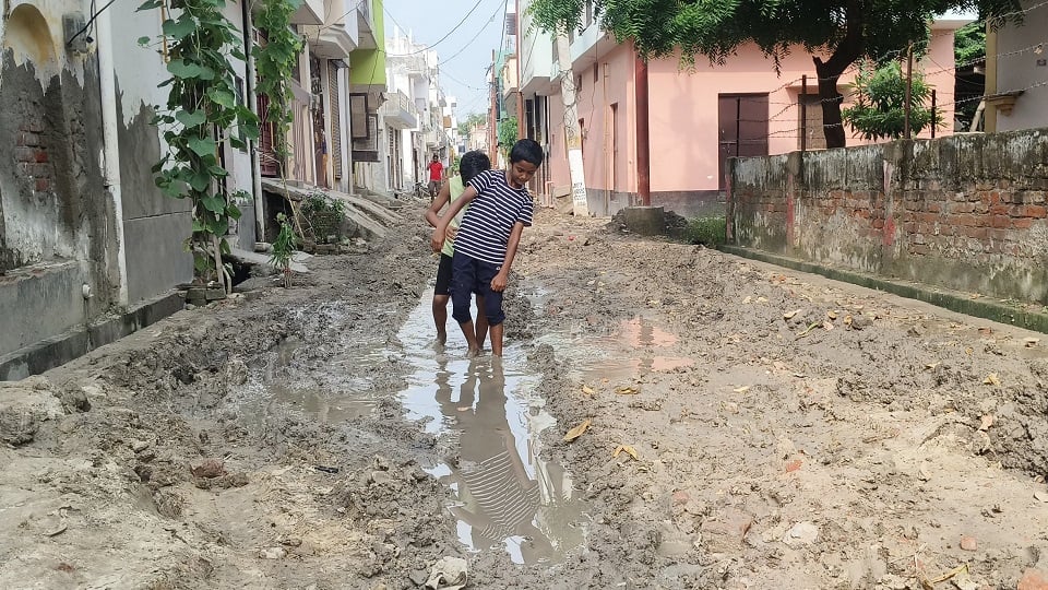 मयूर विहार में कीचड़  में होकर गुजरते बच्चे 