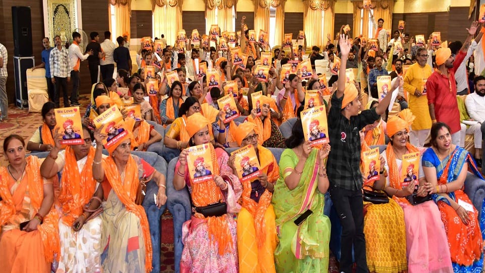 गूलर रोड स्थित एक लॉज में करणी सेना द्वारा शस्त्र पूजन कार्यक्रम में वी लव सनातन के पोस्टर लेकर बैठी महिलाएं