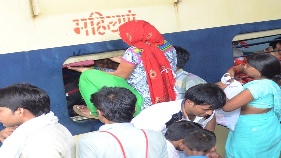 रेलवे स्टेशन पर दीपावली पर ट्रेन में भीड़ होने पर महिला कोच की खिड़की से अंदर घुसती महिला