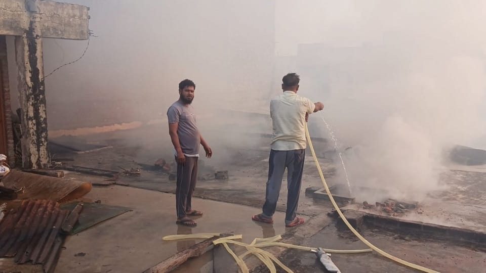 नवीपुर खुर्द  स्थित गलीचा फैक्ट्री में लगी आग छत से समर की पाइप से बुझाते  युवक