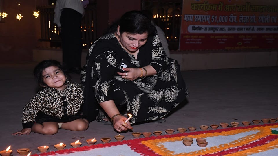 अचल सरोवर में नगर निगम द्वारा दीपोत्सव में दीप जलाती महिला