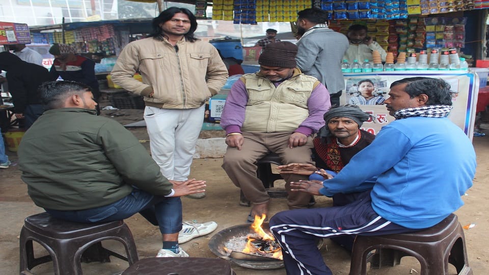 सर्दी से बचाव के लिए अलाव तापते लोग