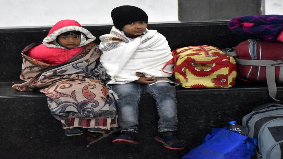 अलीगढ़ रेलवे स्टेशन के प्लेटफार्म नंबर दो पर रात 1.43 बजे ठंड में ठिठुरते बच्चे शॉल ओढ़कर बैठे हुए बैठे 