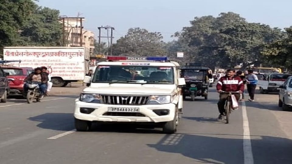 अलीगढ़ रोड पर फटपाथ पर अतिक्रमण बीच जाती पुलिस की गाड़ी