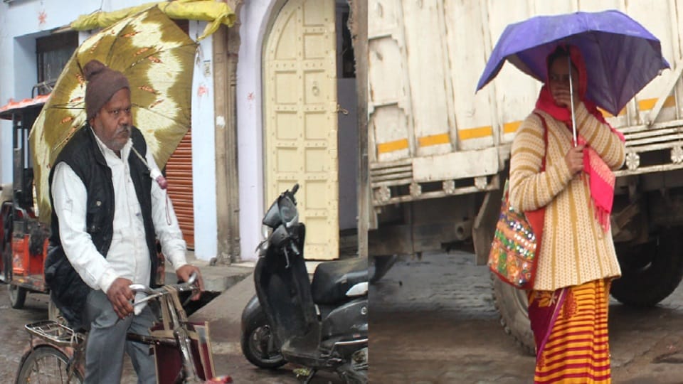 बारिश में छाता लगाकर चलते पुरूष-महिला