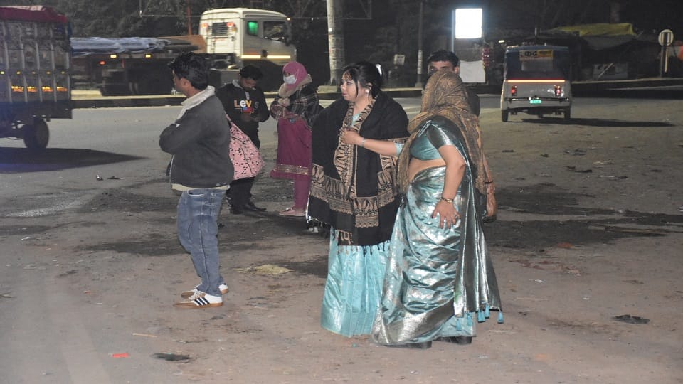 बोनेर हाईवे पर बस के इंतजार में खड़ी महिला यात्री