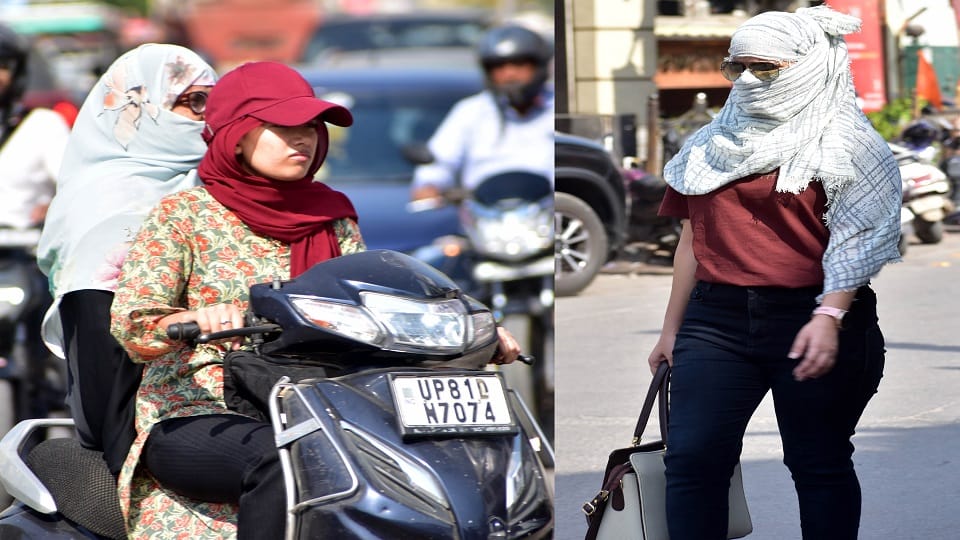 धूप से बचने को खुद को कवर कर स्कूटी पर जाती युवती