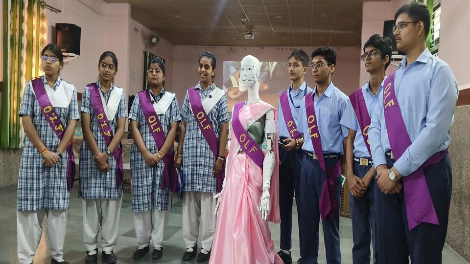 ओएलएफ स्कूल में विद्यार्थियों के द्वारा तैयार किया गया ह्यूमनॉइड रोबोट कैरोलाइन के साथ मौजूद छात्र-छात्राएं