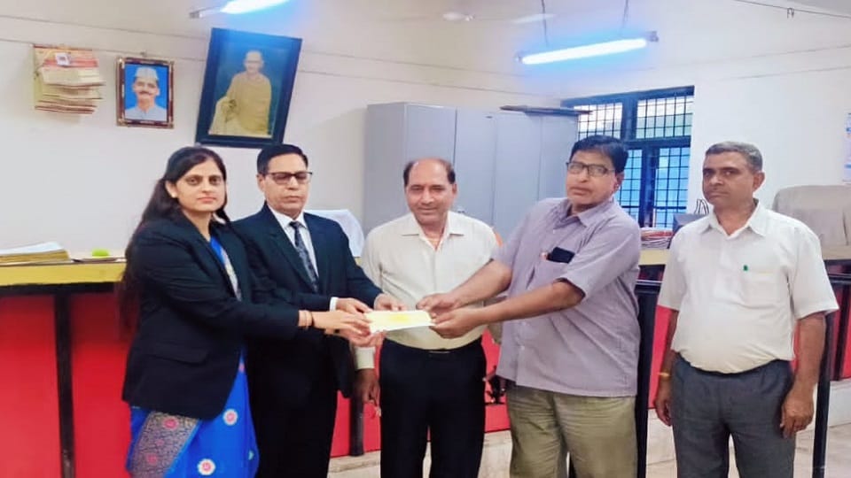 राष्ट्रीय लोक अदालत में चेक वितरण करते पूर्व जिला जज