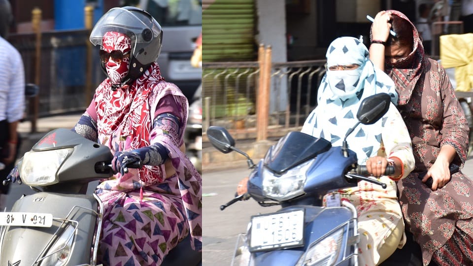 समद रोड पर तेज धूप में कपडे से मुंह ढक कर जाती स्कूटी सवार महिलाएं