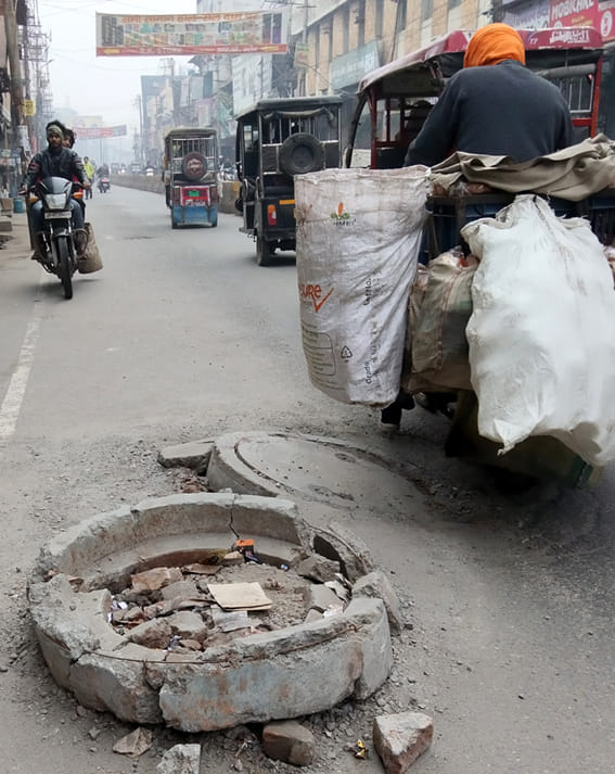 निर्माणाधीन स्मार्ट रोड पर टूटे ढक्कन के ऊपर संकेतक के रूप में रखा गया पत्थर। निर्माणाधीन स्मार्ट रोड पर टूटे ढक्कन के ऊपर संकेतक के रूप में रखा गया पत्थर।