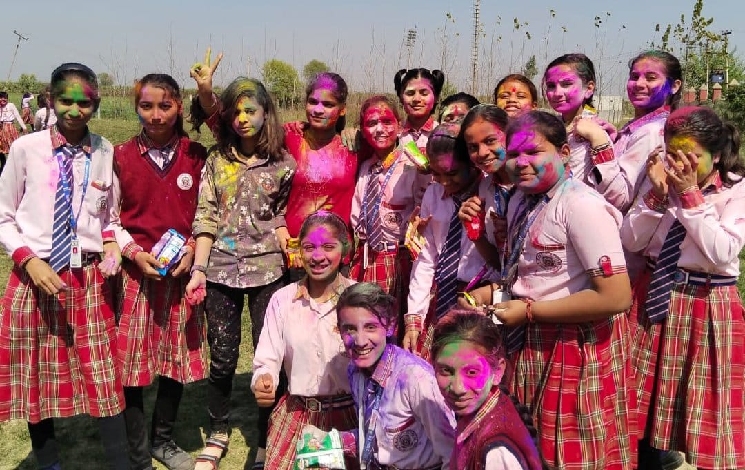 एक्-दूसरे को गुलाल लगाते स्कूली बच्चे एक्-दूसरे को गुलाल लगाते स्कूली बच्चे