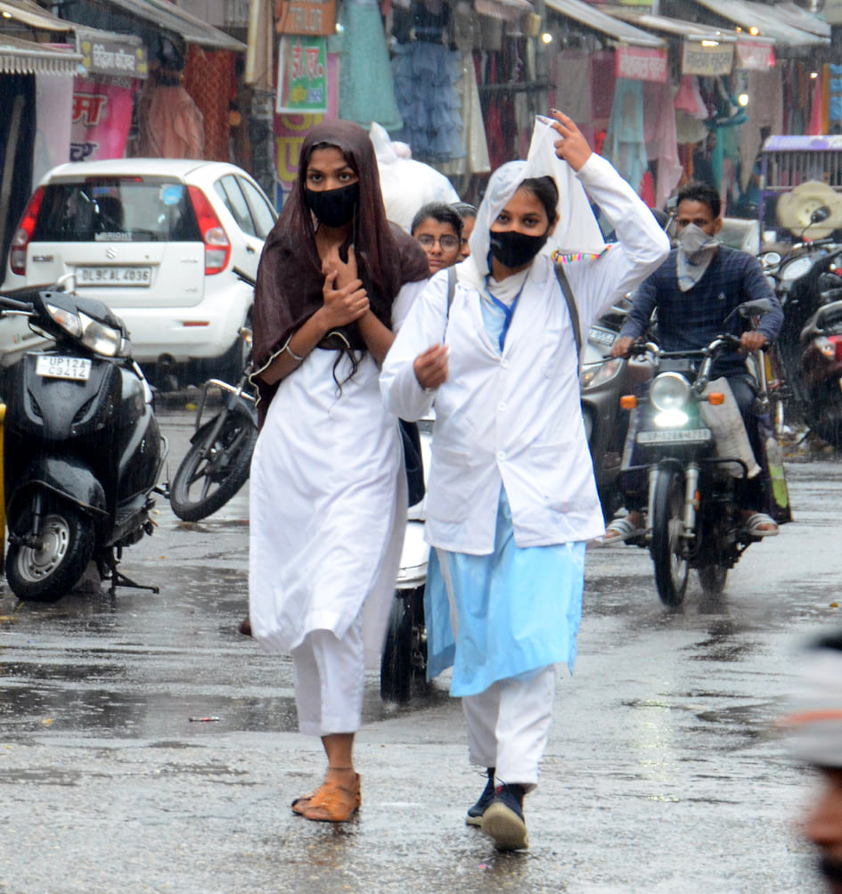 बारिश में पन्नी लपेटकर जाता रिक्शा सवार। बारिश में पन्नी लपेटकर जाता रिक्शा सवार।