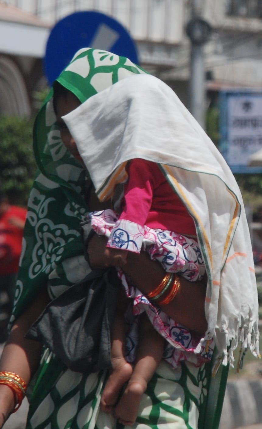 बागपत में गर्म हवा के बीच दुपट्टा लपेटकर जाती महिलाएं बागपत में गर्म हवा के बीच दुपट्टा लपेटकर जाती महिलाएं