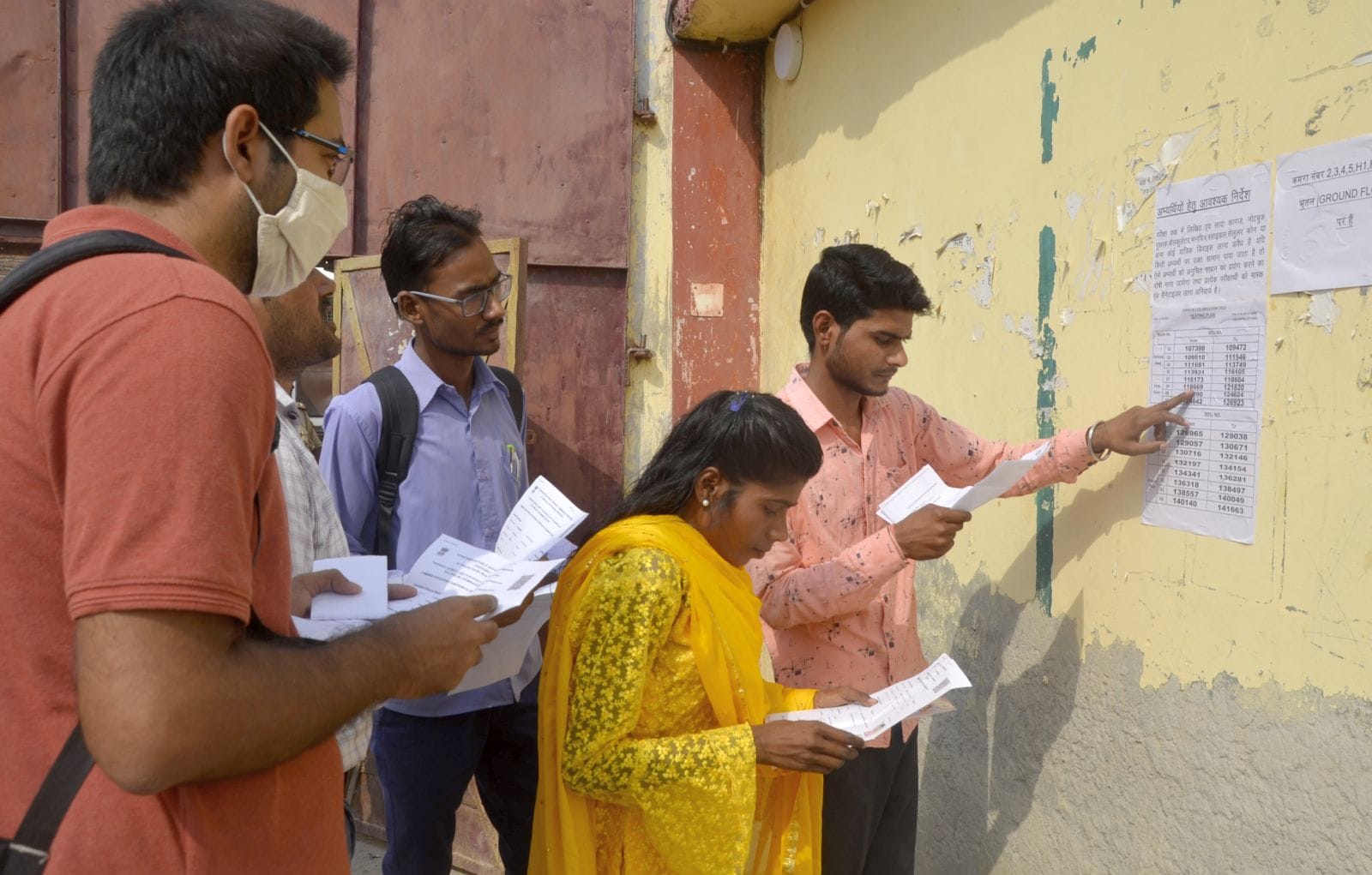 गिंदो देवी महिला डिग्री कॉलेज परीक्षा केंद्र पर चस्पा लिस्ट में अपना कक्ष देखते परिक्षार्थी।संव