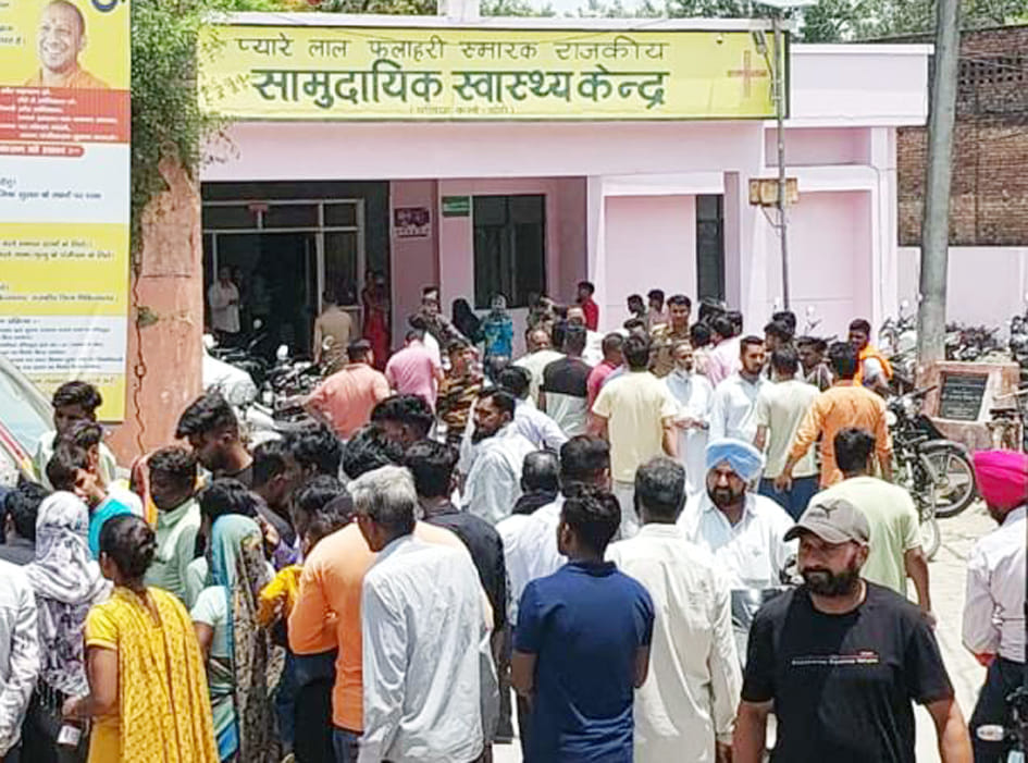 पलिया सीएचसी में मृतक के शव को देखते लोग।