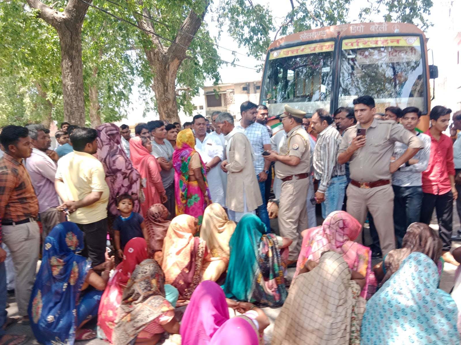 जाम के दौरान रोडवेज बस के नीचे लेटी महिलाएं। संवाद