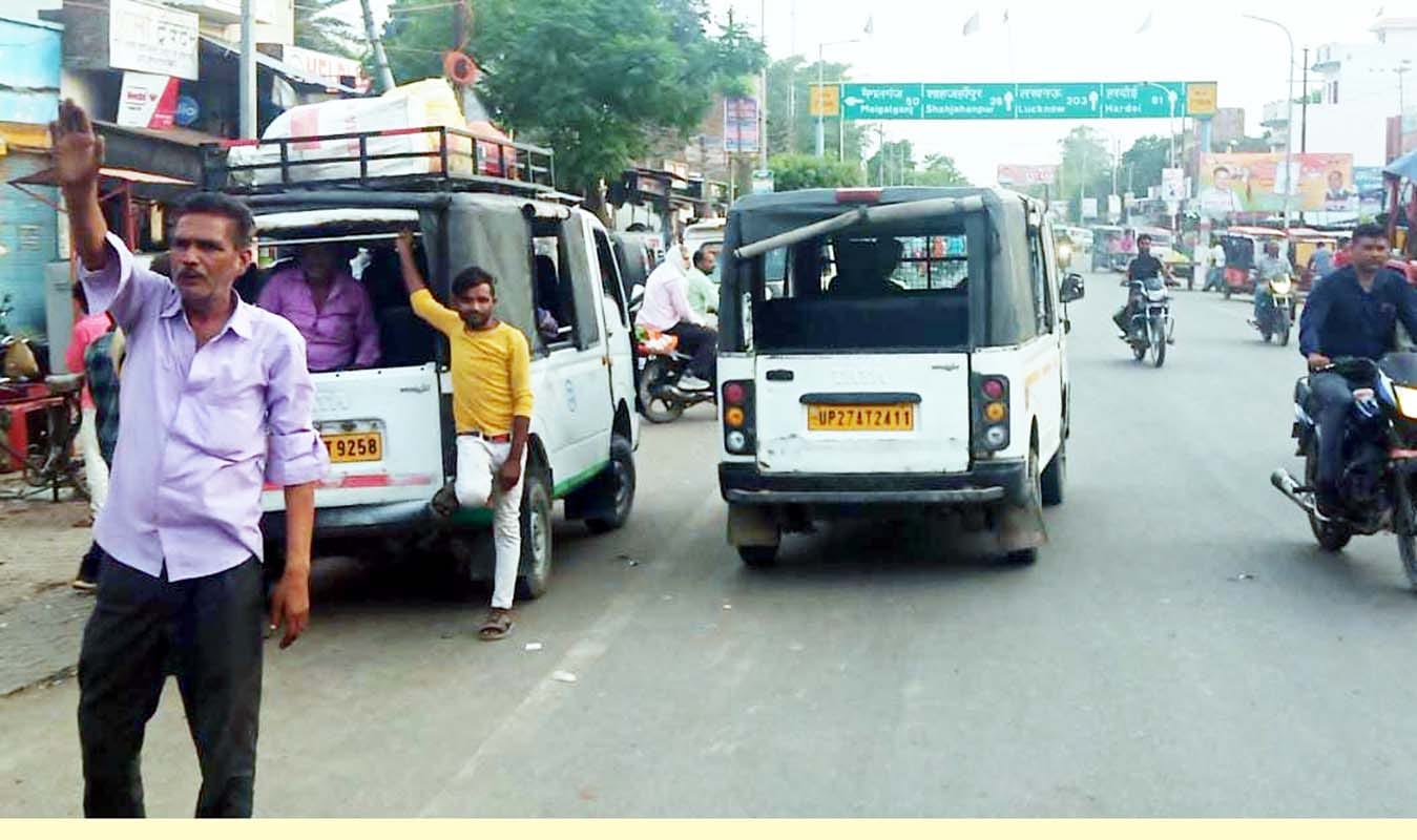 पुवायां में शाहजहांपुर रोड पर हाईवे पर मैजिक खड़ा कर सवारी भरते मैजिक चालक। संवाद