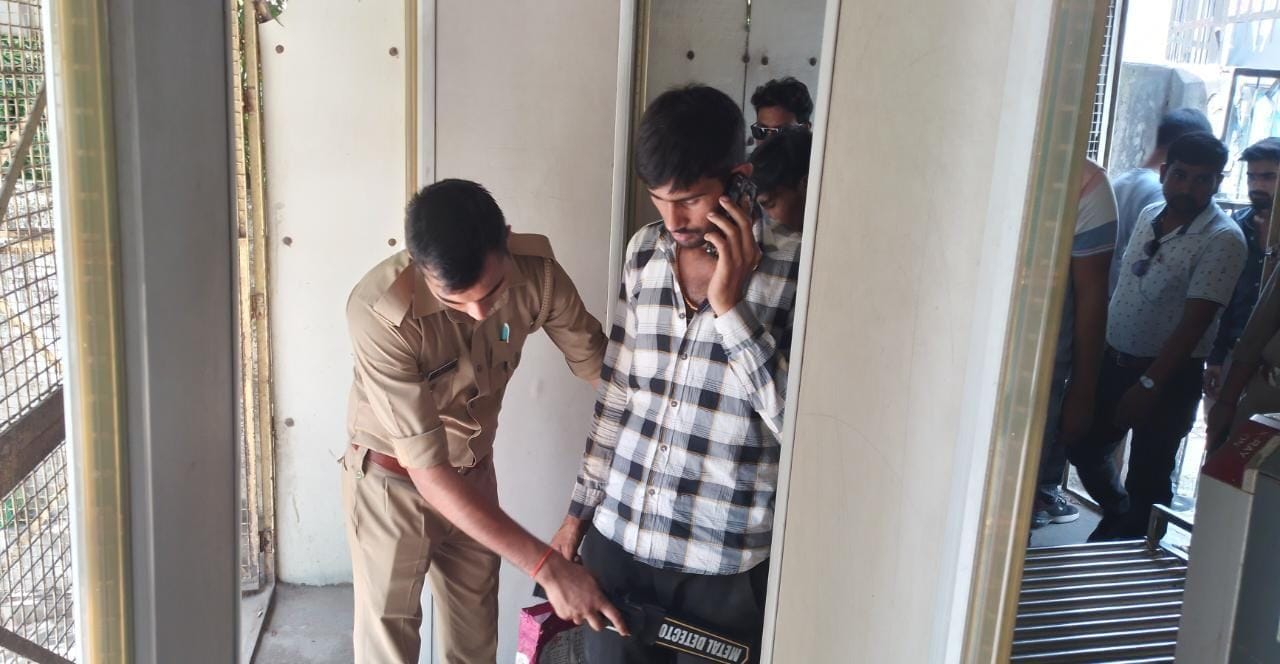 कचहरी गेट पर चेकिंग करता सुरक्षाकर्मी।संवाद