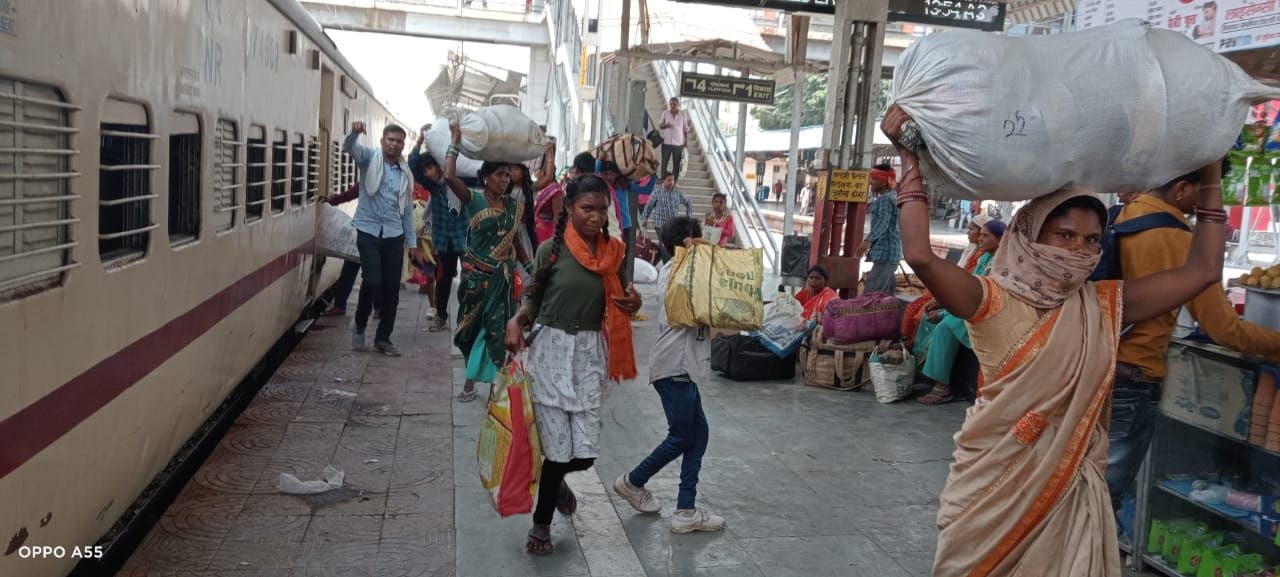 ट्रेन की बोगी में भीड़ के कारण कपड़े से झूला बनाकर बैठा यात्री।