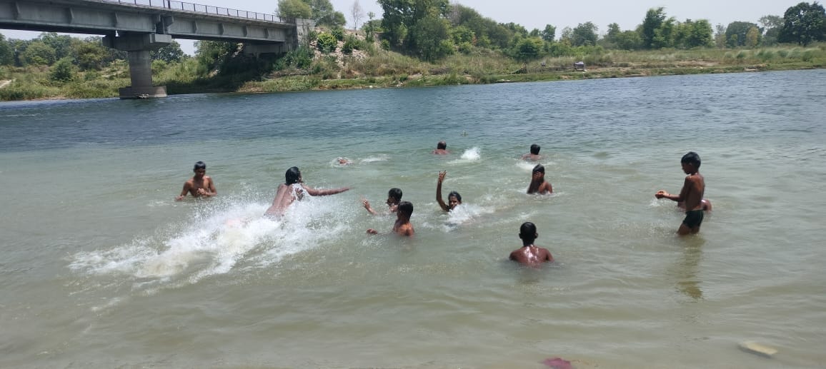 गर्मी से राहत पाने के लिए मुह पर पानी का छीटा मार कर राहत पाते राहगीर।
