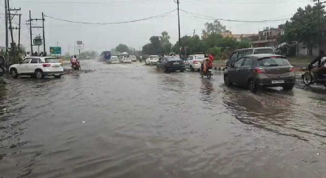 नगर में हुई बारिश में गुजरते छात्र। नगर में हुई बारिश में गुजरते छात्र।