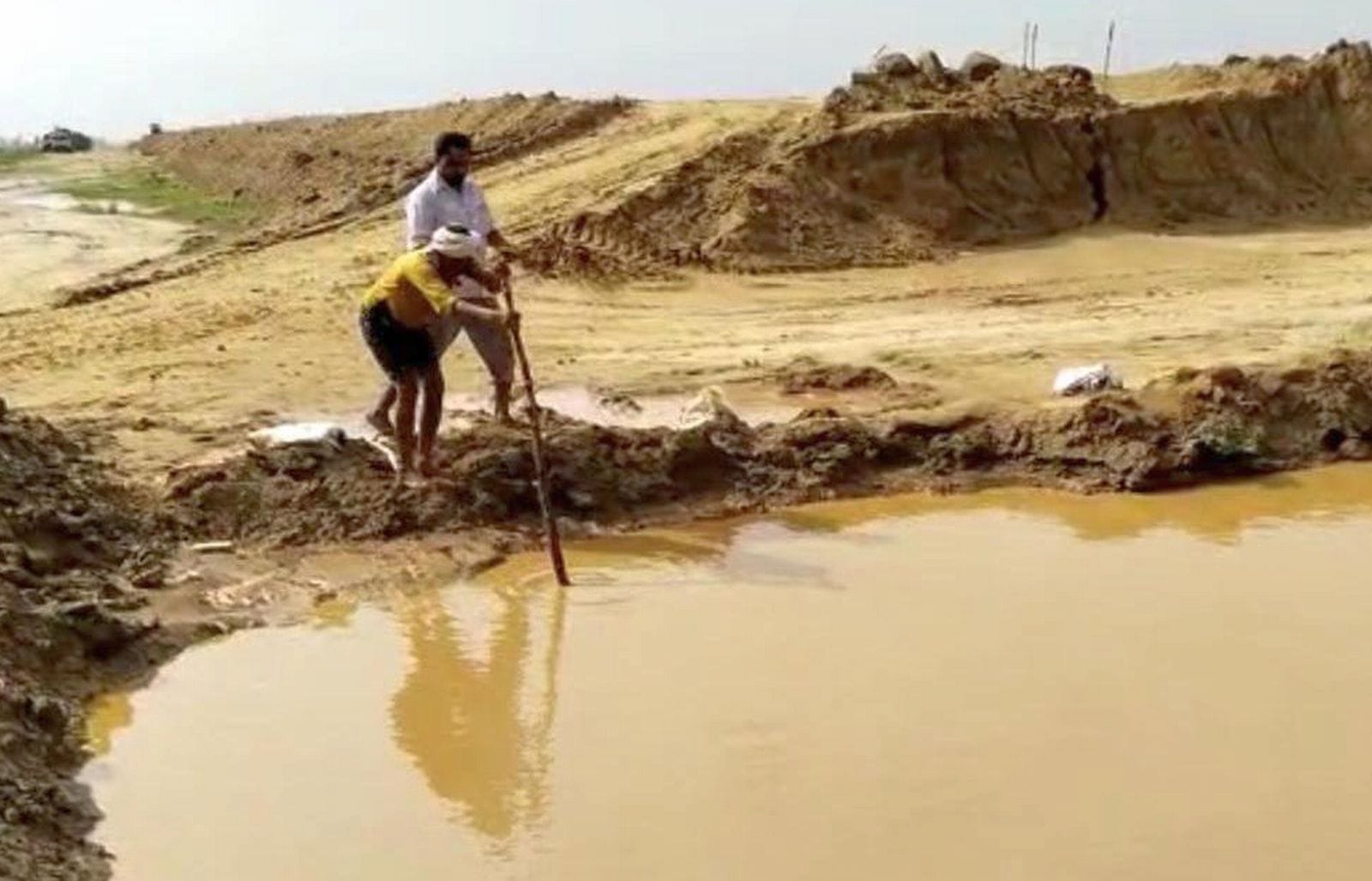 ग्राम नसरौल में गंगा एक्सप्रेेस-वे के गड्ढे की गहराई नापता ग्रामीण। संवाद