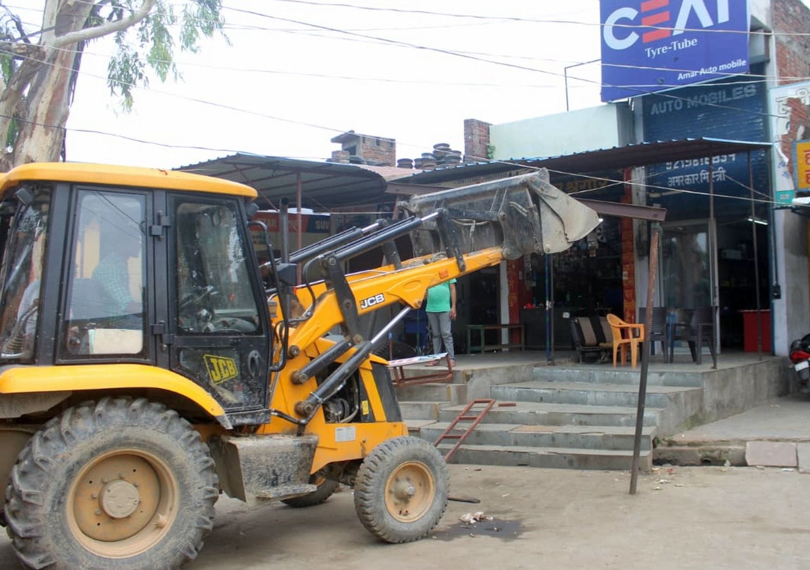 उझानी में अतिक्रमण हटाते पुलिस और पालिका कर्मचारी। संवाद